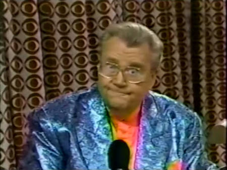 Rod is wearing a blue sequined jacket & salmon collarless silk shirt with matching pocketsquare