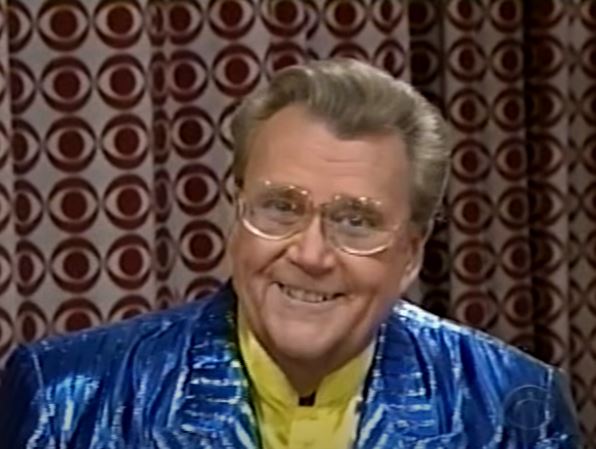 Rod is wearing a shiny blue jacket & yellow silk collarless shirt