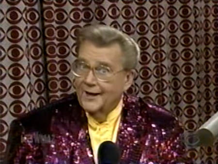 Rod is wearing a maroon sequined jacket & yellow collarless silk shirt