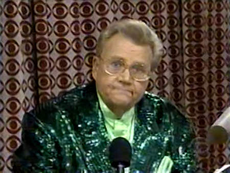 Rod is wearing a dark-green sequined jacket & lime-green collarless silk shirt with matching pocket square