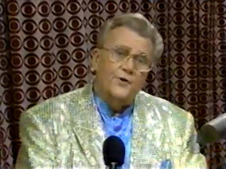 Rod is wearing a gold sequined jacket & light-blue collarless silk shirt with matching pocket square