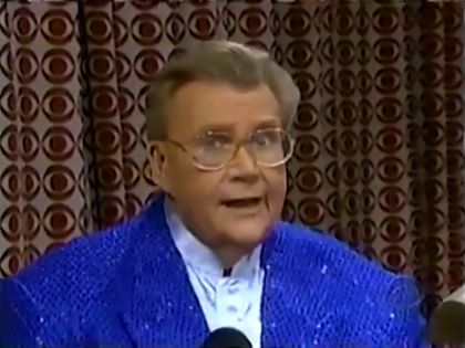 Rod is wearing a blue sequined jacket & white collarless silk shirt