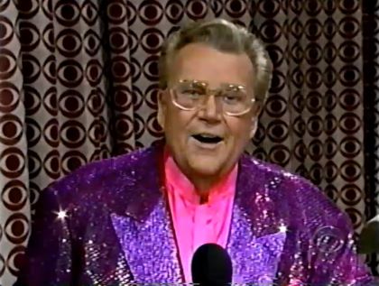 Rod is wearing a purple sequined jacket & pink collarless silk shirt