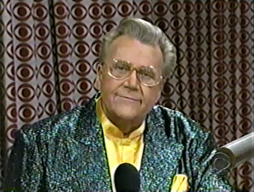 Rod is wearing a dark-green sequined jacket & yellow collarless silk shirt with matching pocket square