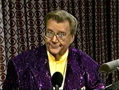 Rod is wearing a purple sequined jacket & yellow collarless silk shirt