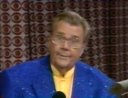 Rod is wearing a blue sequined jacket & yellow collarless silk shirt