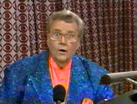 Rod is wearing a blue sequined jacket & salmon collarless silk shirt with matching pocket square