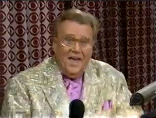 Rod is wearing a gold sequined jacket & lavender collarless silk shirt with matching pocketsquare