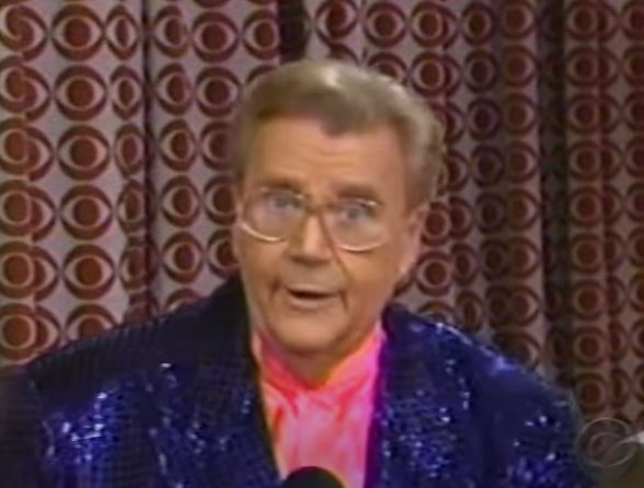 Rod is wearing a dark-purple sequined jacket & salmon collarless silk shirt