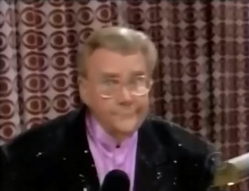 Rod is wearing a black sequined jacket & lavender collarless silk shirt