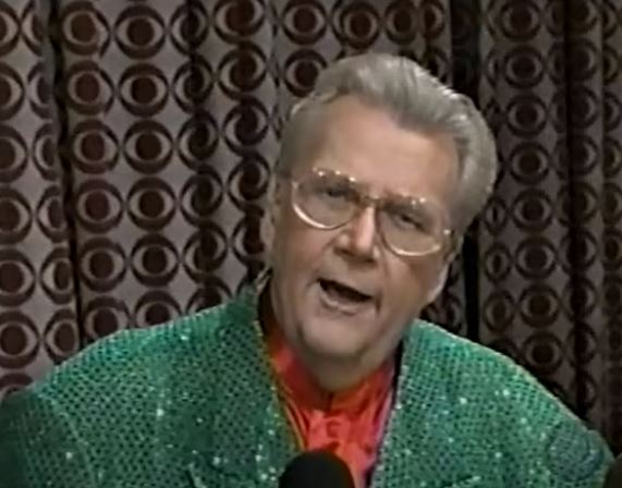 Rod is wearing a green sequined jacket & red collarless silk shirt