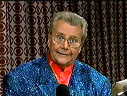 Rod is wearing a blue sequined jacket & red collarless silk shirt