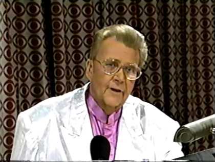 Rod is wearing a silver jacket & lilac collarless silk shirt