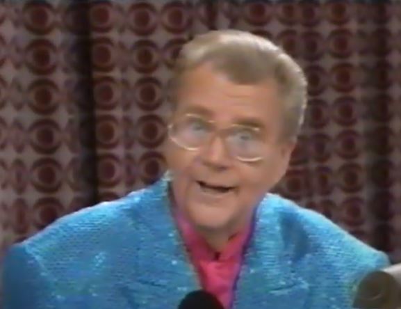 Rod is wearing a blue sequined jacket & pink collarless silk shirt