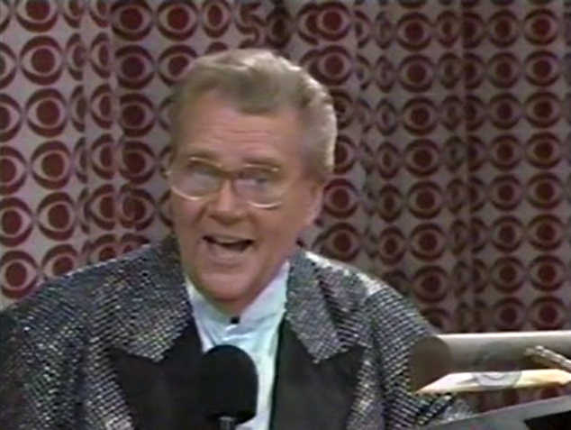 Rod is wearing a black jacket with silver sequins, black lapels & periwinkle collarless silk shirt