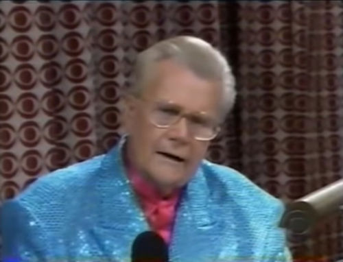 Rod is wearing a blue sequined jacket & fuchsia collarless silk shirt