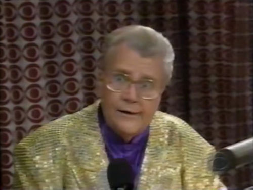 Rod is wearing a gold sequined jacket & purple collarless silk shirt