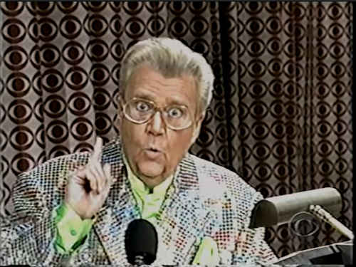 Rod is wearing a multi-colored sequined jacket & lime-green collarless silk shirt with matching pocket square
