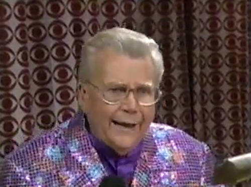 Rod is wearing a purple sequined jacket & purple collarless silk shirt