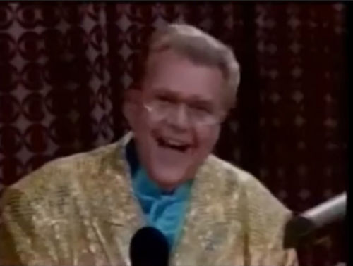 Rod is wearing a gold sequined jacket & light-blue collarless silk shirt