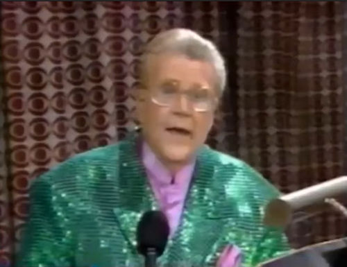 Rod is wearing a green sequined jacket & light-purple collarless silk shirt with matching pocket square