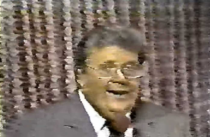 Rod is wearing a grey jacket, necktie & white shirt