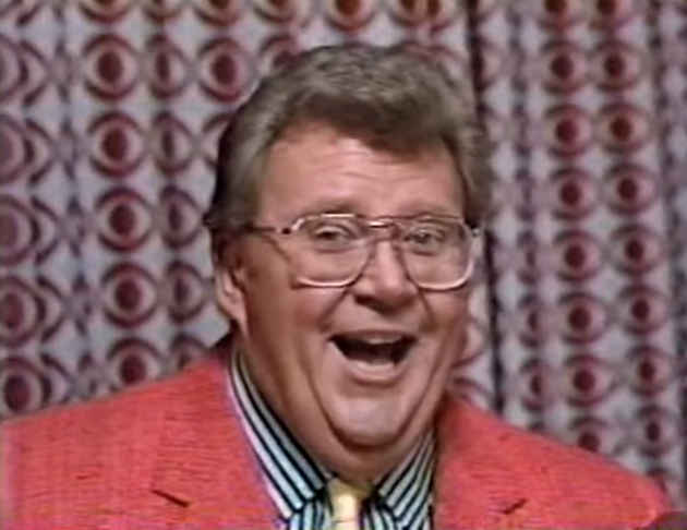Rod is wearing a Pink Jacket, Black & White-striped Shirt & Yellow Tie