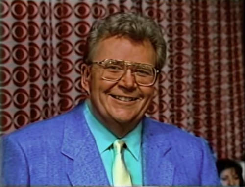 Rod is wearing a blue jacket, gold silk necktie & mint-green shirt