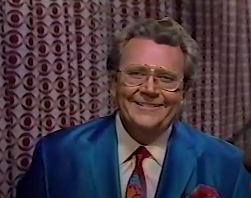 Rod is wearing a blue jacket, matching red tie & pocket square and a white shirt
