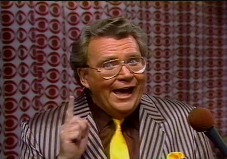 Rod is wearing a brown/grey striped jacket, brown shirt & yellow neck tie with matching pocket square