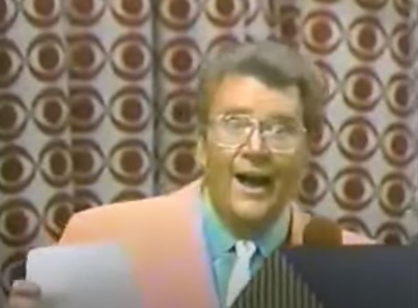 Rod is wearing a peach jacket, green shirt & yellow tie