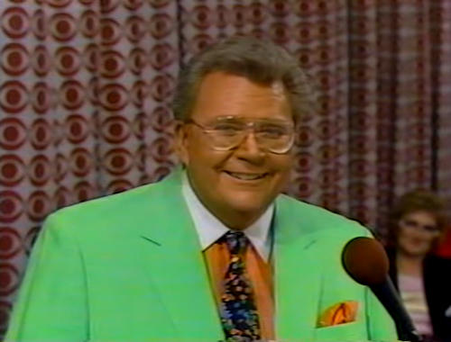Rod is wearing a mint-green jacket, peach shirt with white collar, polka-dot tie & peach pocket square