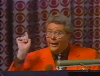 Rod is wearing a Red Jacket, Brown Shirt & Cow-print necktie with matching pocket square