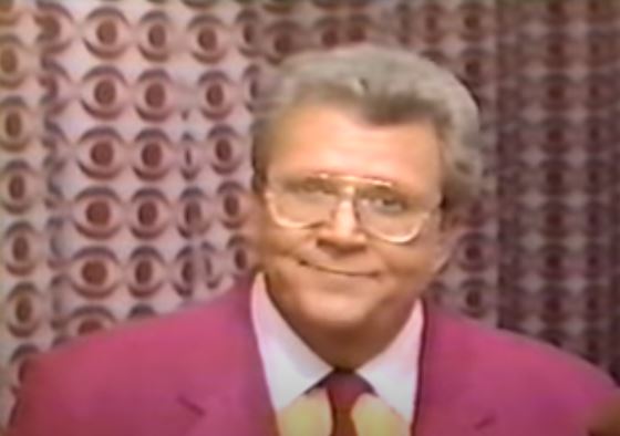 Rod is wearing a pink jacket & tie with a yellow shirt