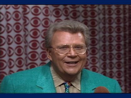 Rod is wearing a green jacket, tan shirt & mottled neck tie