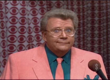 Rod is wearing a coral pink jacket, matching necktie & dark-green shirt with matching pocket square