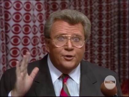Rod is wearing a charcoal jacket, striped necktie & white shirt