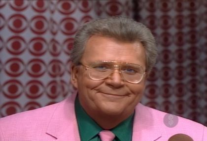 Rod is wearing a pink jacket, matching necktie and dark-green shirt