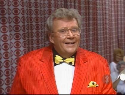 Rod is wearing a red/red-pinstriped jacket, white tuxedo shirt with black collar and yellow bow tie with black polka dots