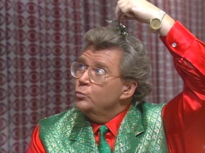 Rod is wearing a shiny green vest, red silk shirt & green necktie with white dots