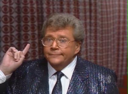 Rod is wearing a navy-blue sequined jacket with matching neck tie & white shirt