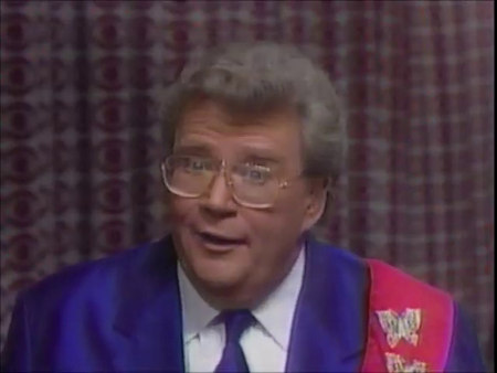 Rod is wearing a purple silk jacket with matching necktie, white shirt & a red sash with gold butterflies