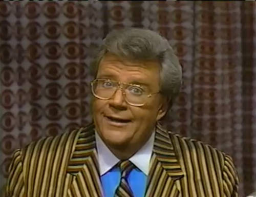 Rod is wearing a Brown-Tan-Black Striped jacket, matching necktie & a blue shirt with a white collar