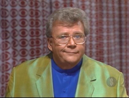 Rod is wearing an olive-green silk jacket & blue collarless shirt