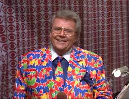 Rod is wearing a Southwest-patterned jacket, matching necktie, dark-blue shirt with a white collar & matching pocket square