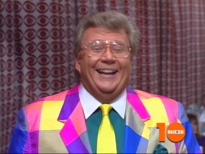 Rod is wearing a multi-colored patchwork jacket, yellow necktie, seafoam-green shirt with white collar and matching pocket square