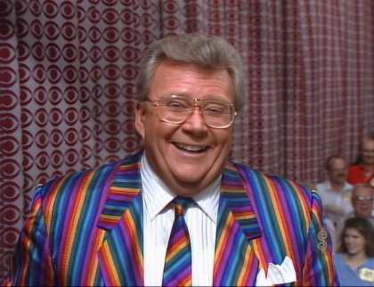 Rod is wearing a rainbow-striped jacket, matching necktie & white shirt with matching pocket square