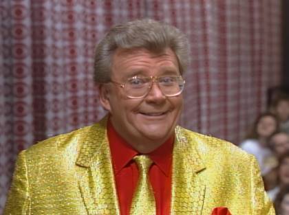 Rod is wearing a gold jacket, matching necktie & red shirt with matching pocket square