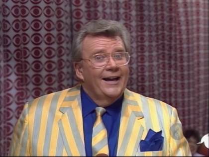 Rod is wearing a yellow/grey striped jacket, matching necktie and a dark-blue shirt with matching pocket square