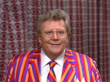 Rod is wearing an orange/red/purple striped jacket with matching necktie & white shirt